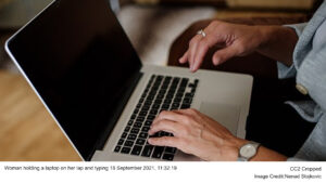 Woman holding a laptop on her lap and typing 18 September 2021, 11:32:19